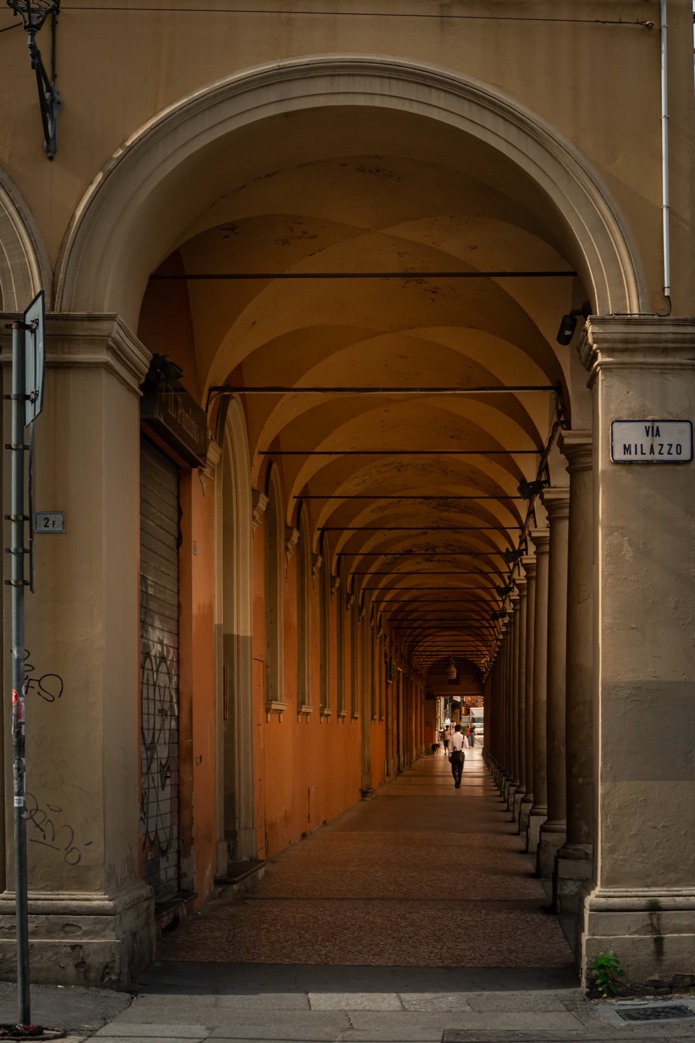 Ochre arches along a covered walkway in Bologna